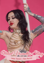 Velvet Vixenettes sling: online tutorial, video pack 1. Wednesday is posing in a white sling wearing gold chain lingerie halter top and gold pasties. She has long black hair and red lips.